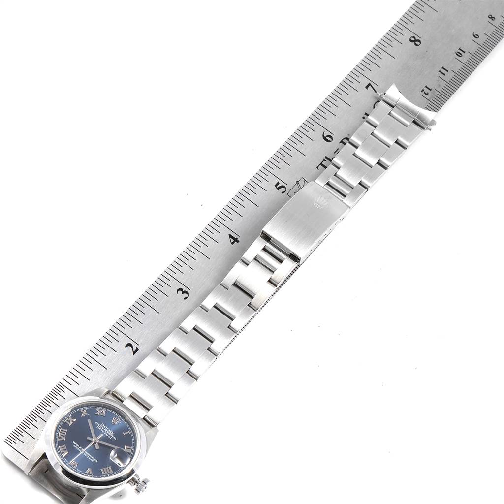 This image shows a Mid-Size Rolex watch's face and stainless steel bracelet, measured against a ruler.