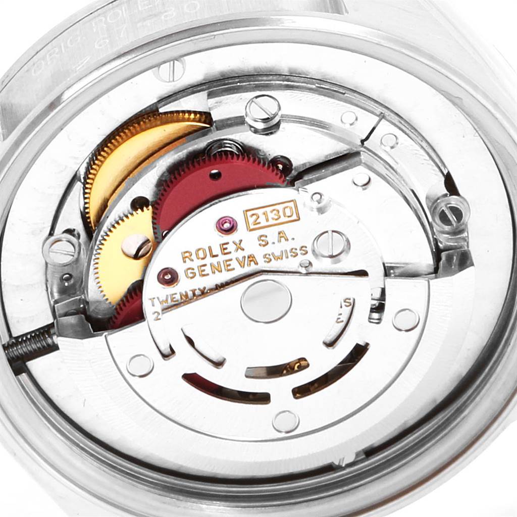 The image shows an internal view of the movement mechanism of a Rolex Mid-Size 67480 Women's Stainless Steel Silver Dial 67480 Women's Stainless Steel Silver Dial model, highlighting gears and engravings.