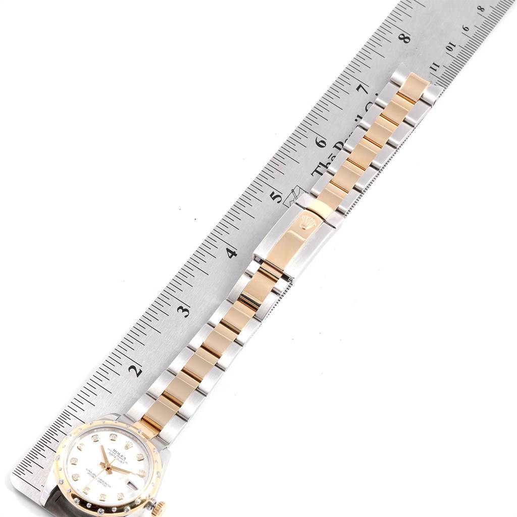 The image shows a Rolex Mid-Size 178343 Women's Steel and Gold (two tone) White Dial 178343 Women's Steel and Gold (two tone) White Dial watch with a view of its dial, bracelet, and clasp, placed alongside a ruler for measurement.