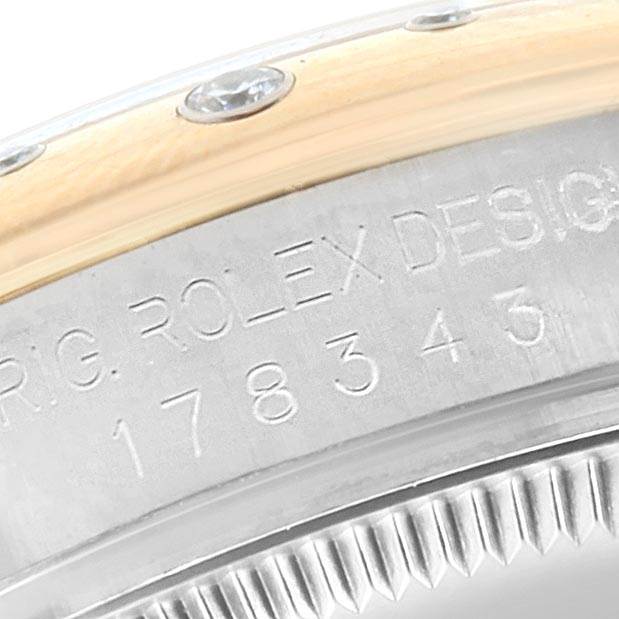 The image shows the side view of a Rolex Mid-Size 178343 Women's Steel and Gold (two tone) White Dial 178343 Women's Steel and Gold (two tone) White Dial model, focusing on the serial and model number engraving on the case.