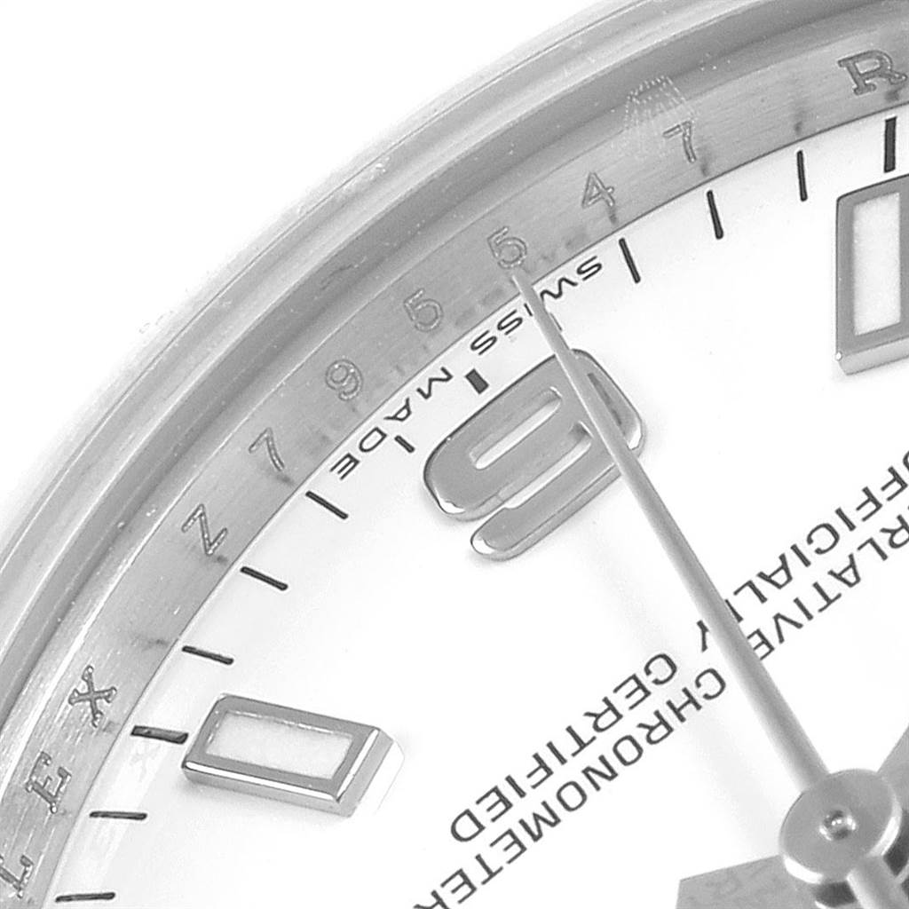 The image shows the face of a Mid-Size Rolex watch at a close-up angle, highlighting the hour markers, hands, and part of the bezel.