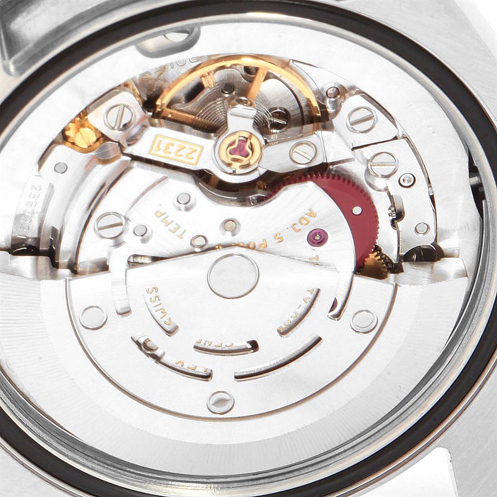 The image displays a close-up view of the internal mechanism of a Mid-Size Rolex watch.