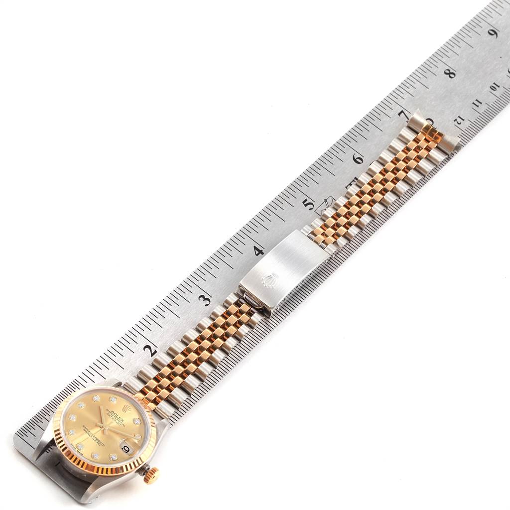 The image shows a Rolex Mid-Size 78273 Women's Steel and Gold (two tone) Champagne Dial 78273 Women's Steel and Gold (two tone) Champagne Dial watch laid next to a ruler, showcasing the face, bezel, band, and clasp.