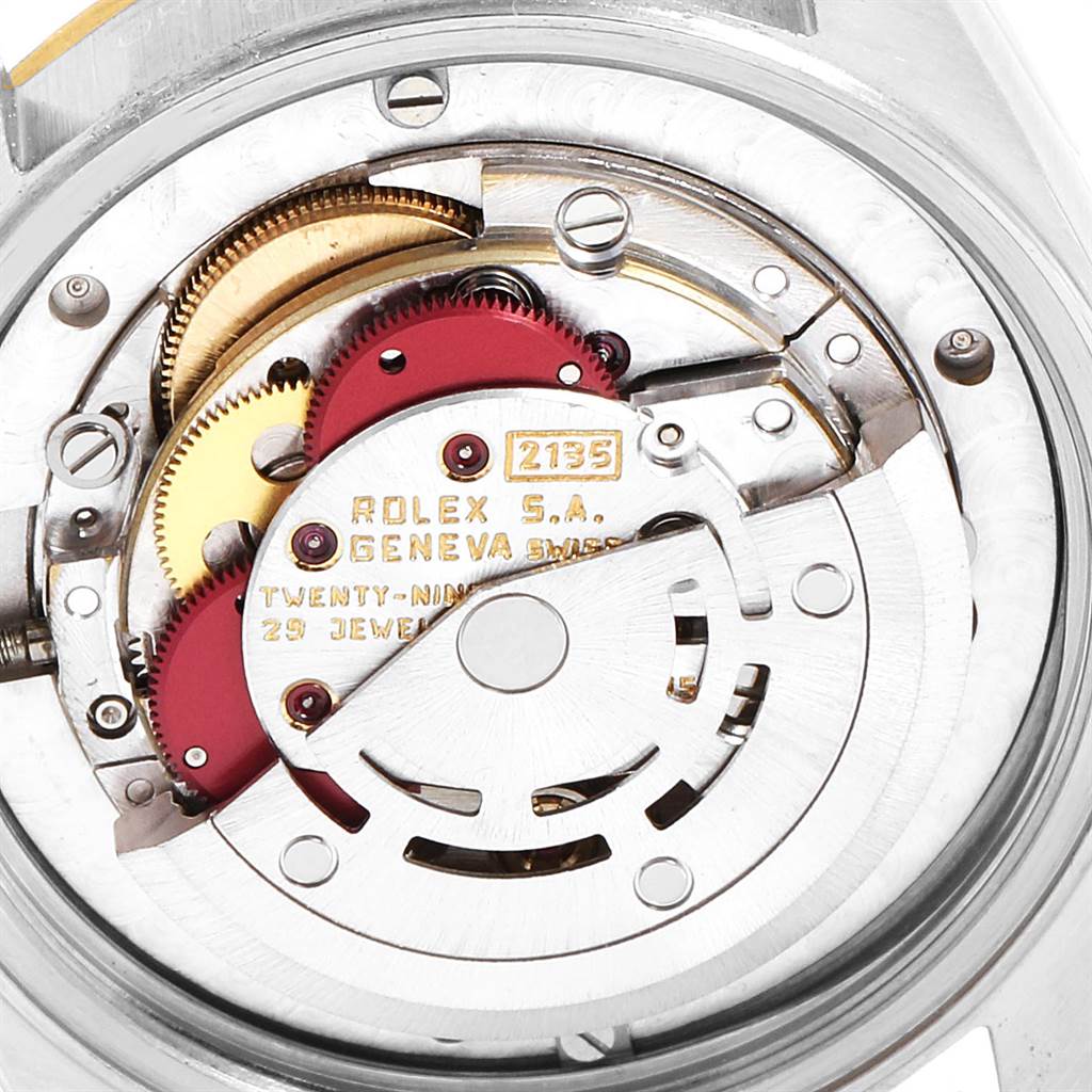This image shows the internal mechanism of a Mid-Size Rolex watch, including gears and the escapement system.