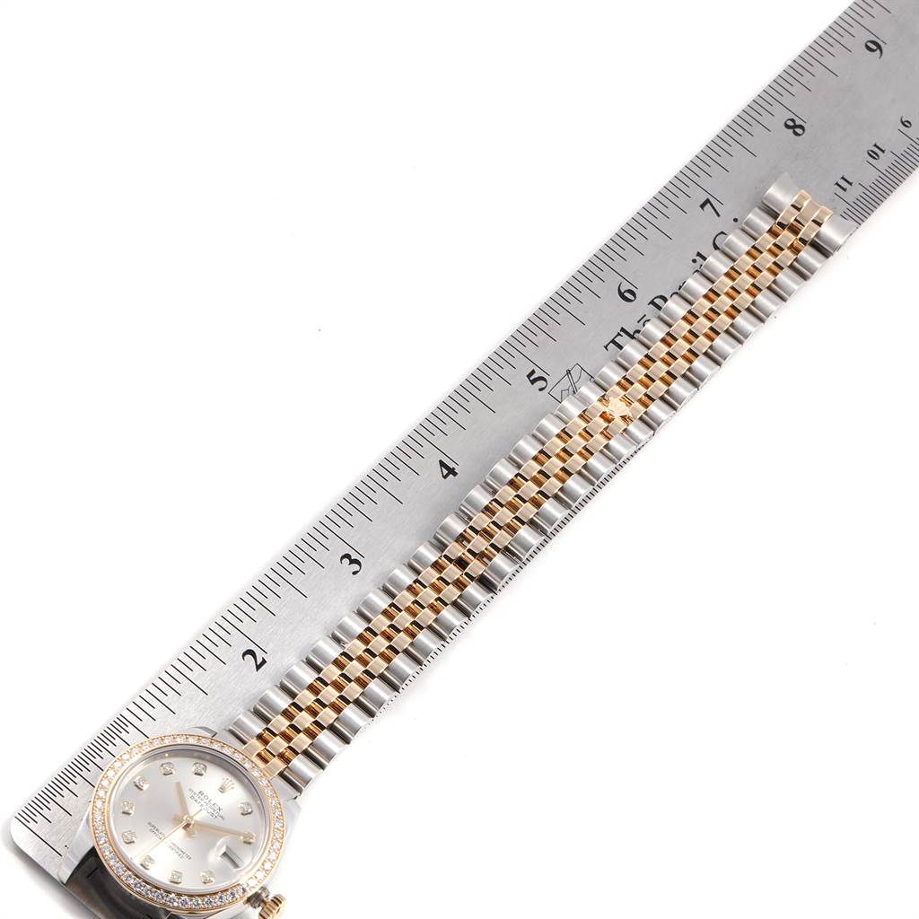 The image shows a top view of a Rolex Mid-Size 178383 Women's Steel and Gold (two tone) Silver Dial 178383 Women's Steel and Gold (two tone) Silver Dial model watch, featuring the face and bracelet alongside a ruler.