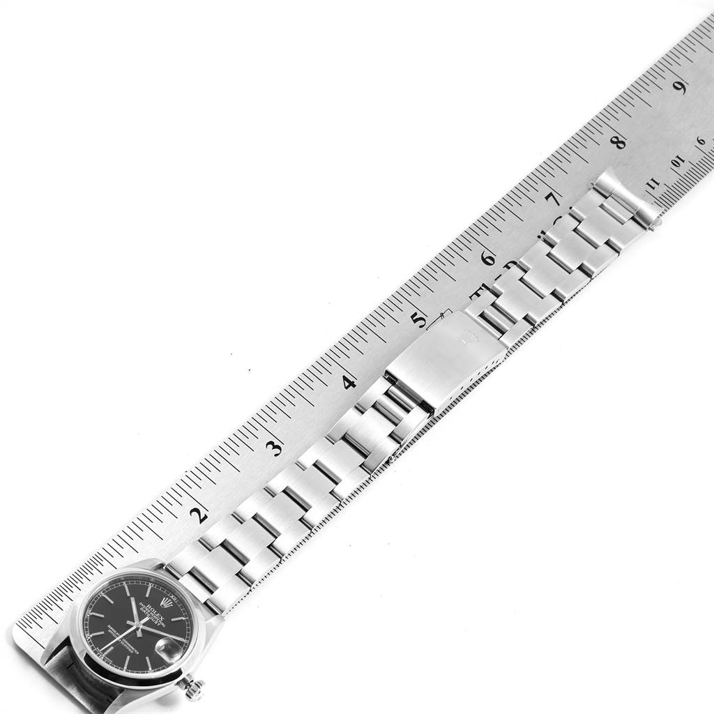 The image shows a Rolex Mid-Size 78240 Women's Stainless Steel Black Dial 78240 Women's Stainless Steel Black Dial watch laying flat with its metal bracelet extended and measured against a ruler.