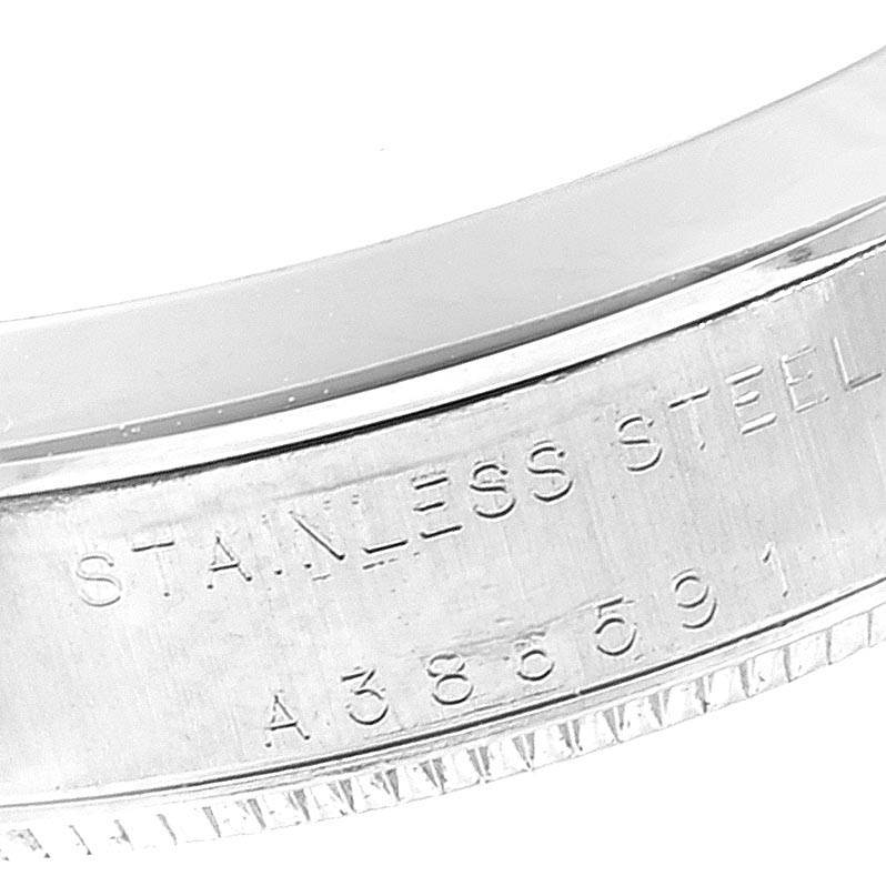 A close-up of the side casing of a Rolex Mid-Size 77080 Women's Stainless Steel White Dial 77080 Women's Stainless Steel White Dial watch, showing the "STAINLESS STEEL" engraving and part of the serial number.