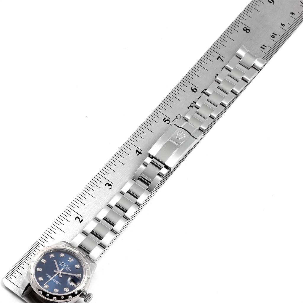 The image shows a Rolex Mid-Size 178344 Women's Stainless Steel Blue Dial 178344 Women's Stainless Steel Blue Dial watch flat on its back, displaying the dial, bracelet, and clasp alongside a ruler for measurement.