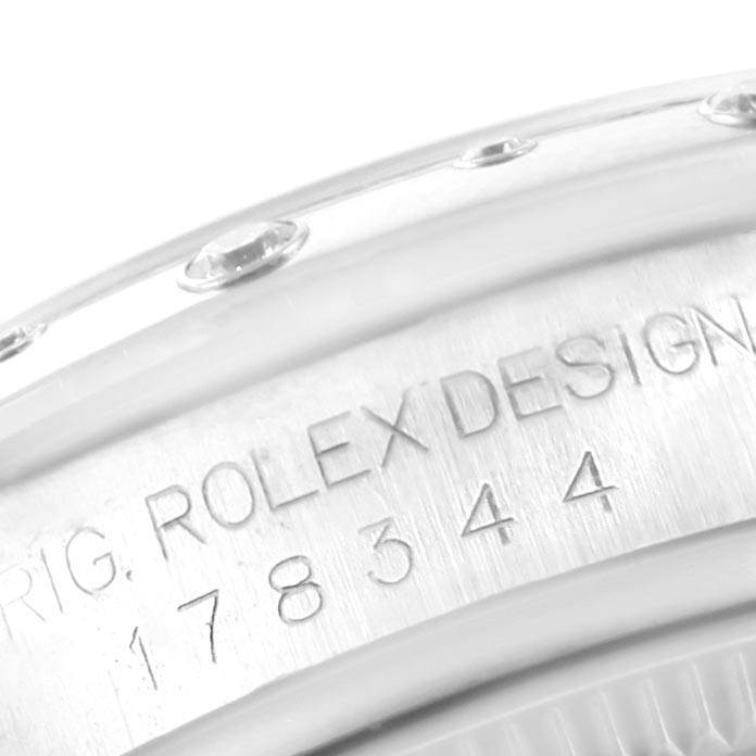 This close-up image of a Mid-Size Rolex watch shows the engraved serial number and part of the bezel.