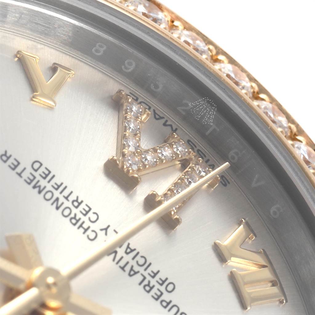 The image shows a close-up angle of a Rolex Mid-Size 178383 Women's Steel and Gold (two tone) Silver Dial 178383 Women's Steel and Gold (two tone) Silver Dial watch, focusing on part of the dial with diamond-accented Roman numerals and the bezel.