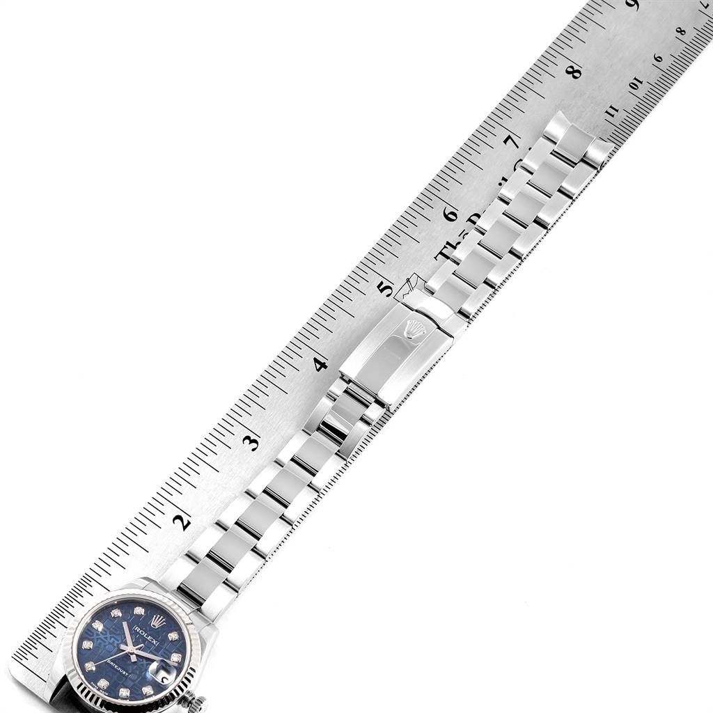 The image shows a Mid-Size Rolex watch placed next to a ruler, highlighting the bracelet and clasp of the watch up to the face.