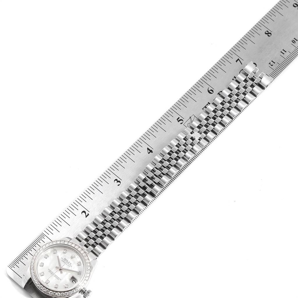 The image shows a Rolex Mid-Size 178384 Women's Stainless Steel Mother of Pearl Dial 178384 Women's Stainless Steel Mother of Pearl Dial model watch with its band fully extended and aligned next to a ruler.