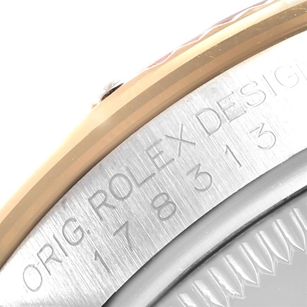 This close-up image shows the engraved outer edge and part of the bezel of a Mid-Size Rolex watch.
