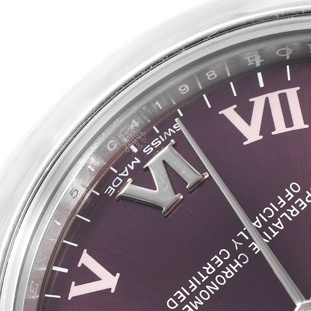 This close-up of the Rolex Mid-Size 177200 Women's Stainless Steel Burgundy Dial 177200 Women's Stainless Steel Burgundy Dial watch shows part of its purple dial with Roman numerals VI and VII and the second hand.