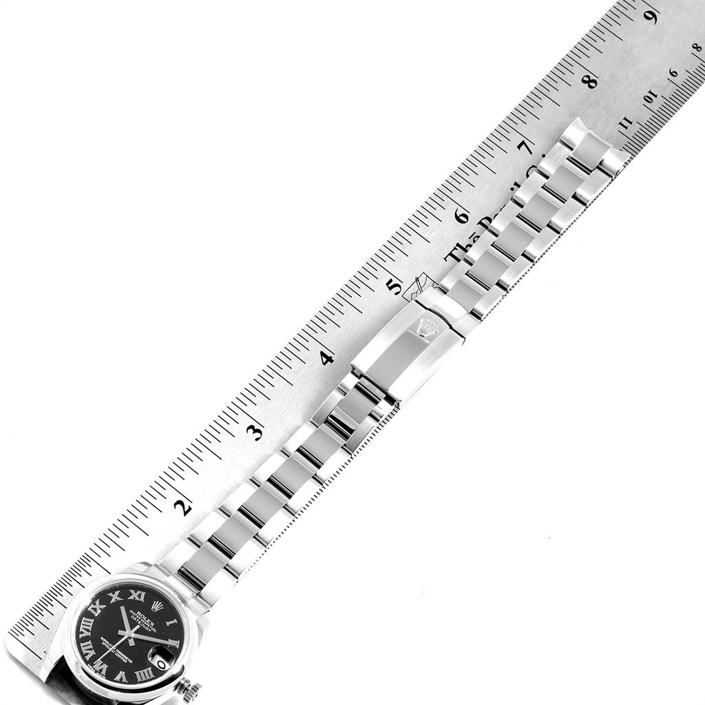 The image shows a Rolex Mid-Size 178240 Women
s Stainless Steel Black Dial 178240 Women
s Stainless Steel Black Dial watch lying flat, with its face, bracelet, and clasp clearly visible alongside a ruler for measurement.