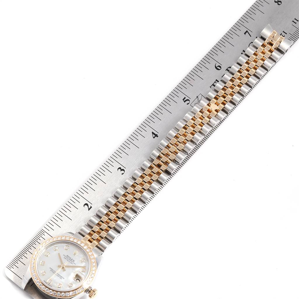 The image shows a Rolex Mid-Size 178383 Women
s Steel and Gold (two tone) Mother of Pearl Dial 178383 Women
s Steel and Gold (two tone) Mother of Pearl Dial watch laid flat with its dial, bezel, and bracelet fully visible next to a measuring ruler.