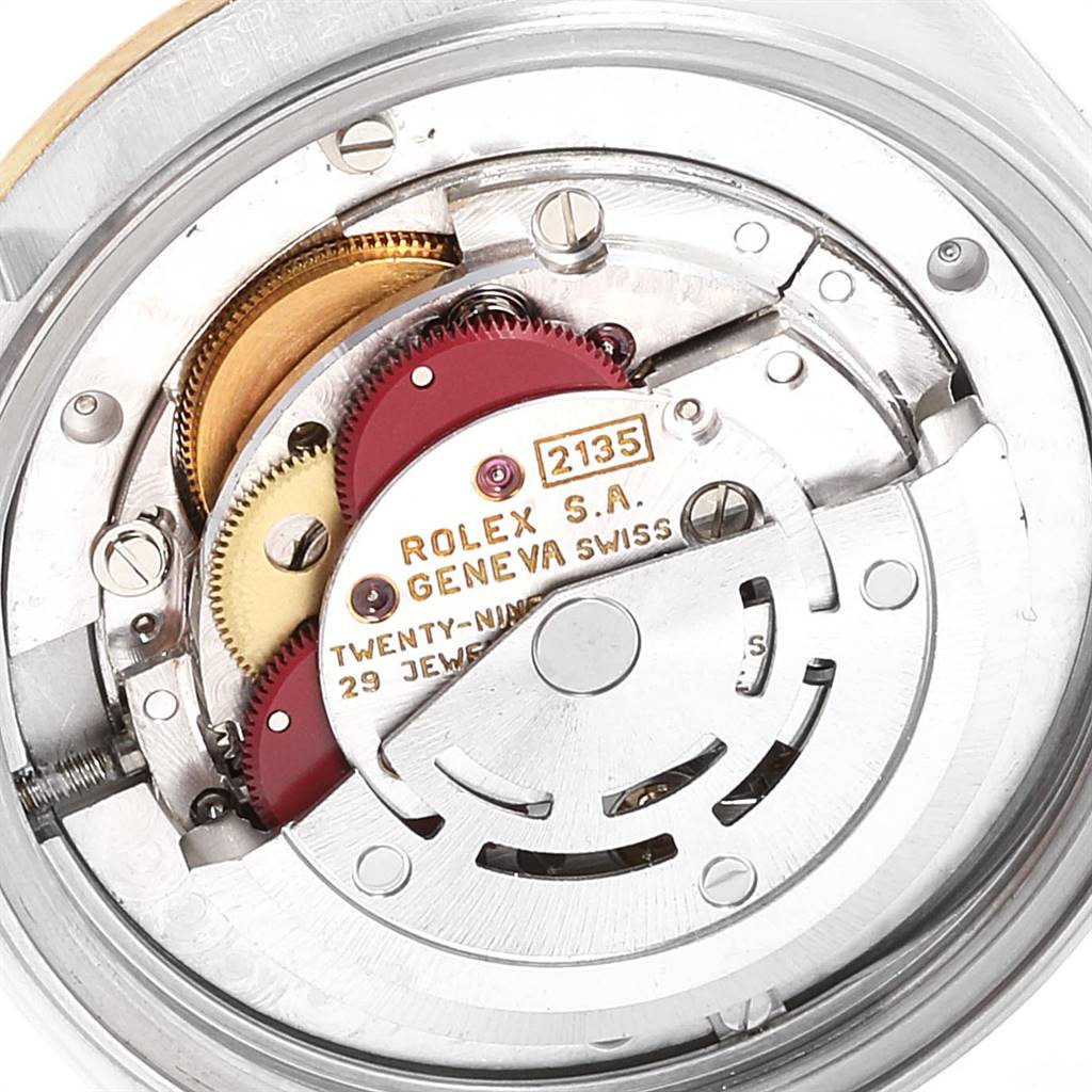 This image shows the internal movement mechanism of a Mid-Size Rolex watch model 2135, highlighting its intricate gears and components.