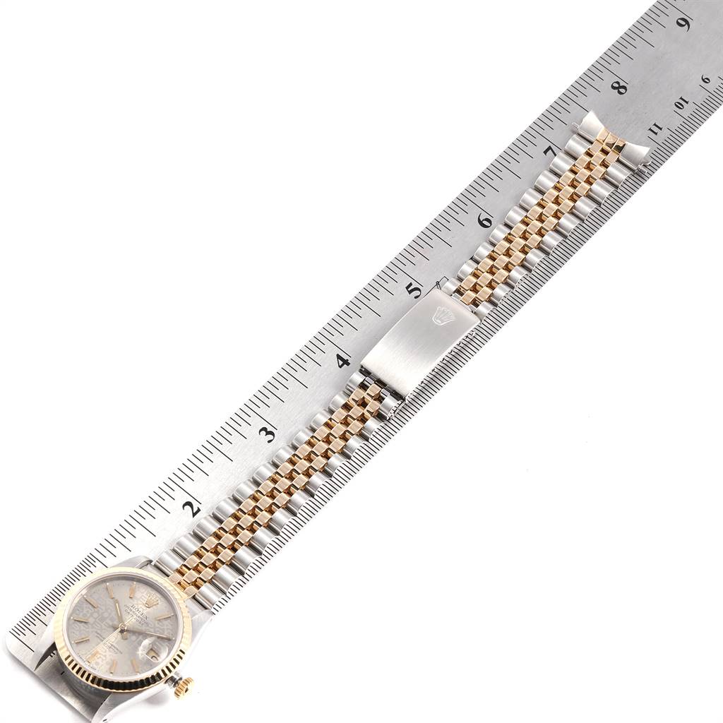 The Rolex Mid-Size 68273 Women's Steel and Gold (two tone) Silver Dial 68273 Women's Steel and Gold (two tone) Silver Dial watch is shown from the top, featuring its face, crown, and bracelet, positioned next to a ruler.