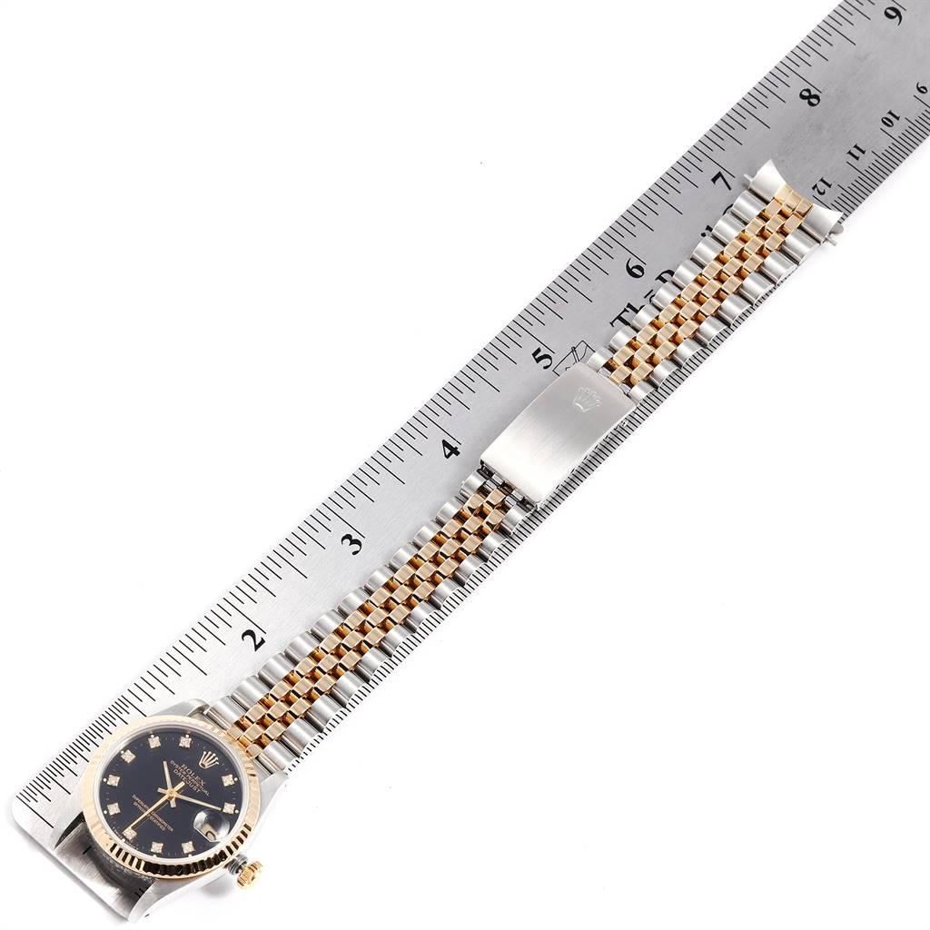 The image shows a Mid-Size Rolex watch with its strap and clasp, laid next to a ruler for measurement.