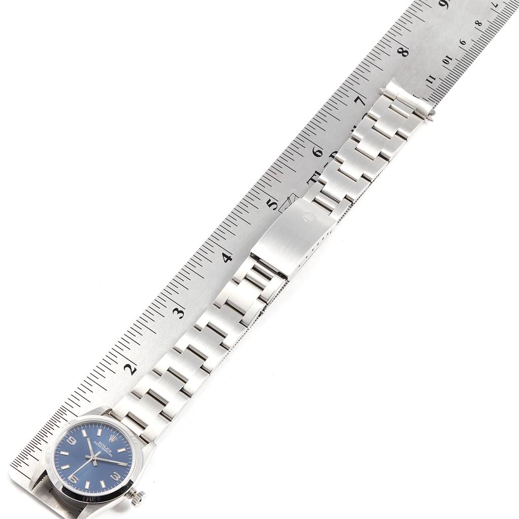 The image shows a Rolex Mid-Size 67480 Women's Stainless Steel Blue Dial 67480 Women's Stainless Steel Blue Dial model watch positioned next to a ruler, displaying its entire bracelet and part of the watch face.