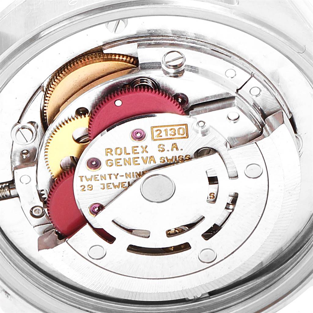 This image shows the internal movement mechanism of a Rolex Mid-Size 67480 Women's Stainless Steel Blue Dial 67480 Women's Stainless Steel Blue Dial watch, model 2130, including gears and the balance wheel.