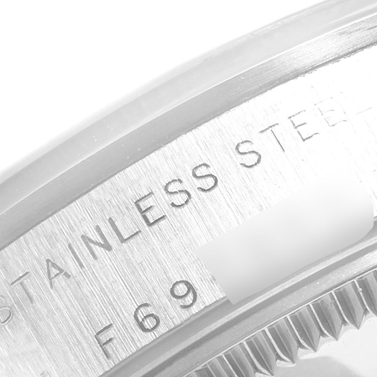 This image shows a close-up angle of the back casing of a Mid-Size Rolex watch, highlighting the "STAINLESS STEEL" engraving.
