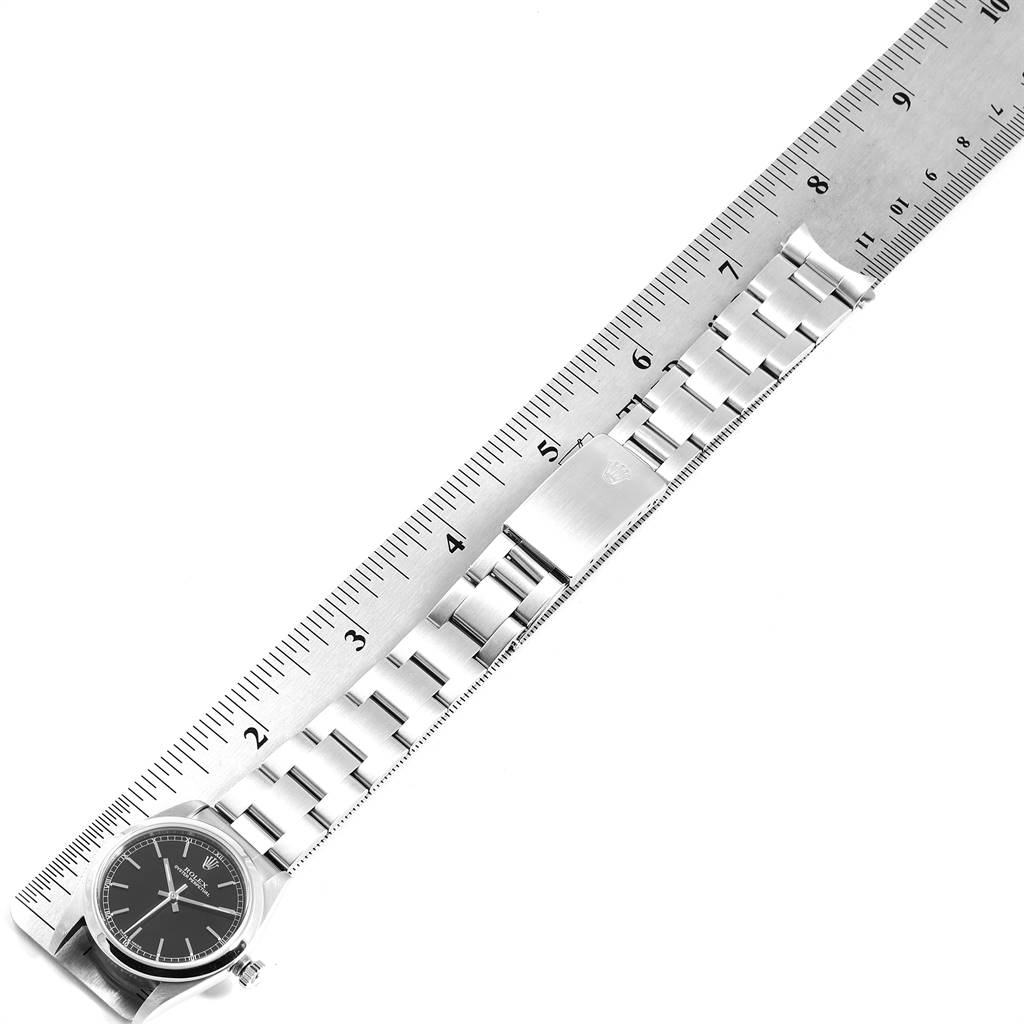 This image shows a Rolex Mid-Size 77080 Women's Stainless Steel Black Dial 77080 Women's Stainless Steel Black Dial watch laid flat beside a ruler, with the watch face and stainless steel bracelet visible.