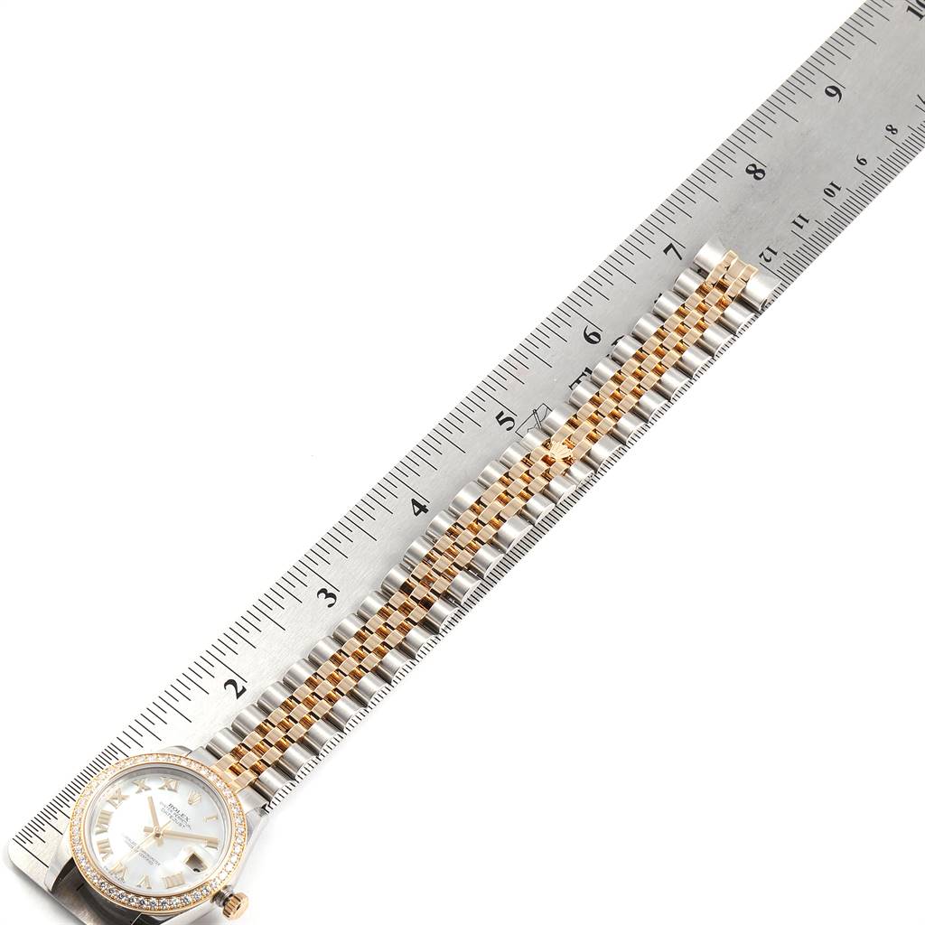The image showcases a Rolex Mid-Size 178383 Women's Steel and Gold (two tone) Mother of Pearl Dial 178383 Women's Steel and Gold (two tone) Mother of Pearl Dial watch face and bracelet alongside a ruler for scale.