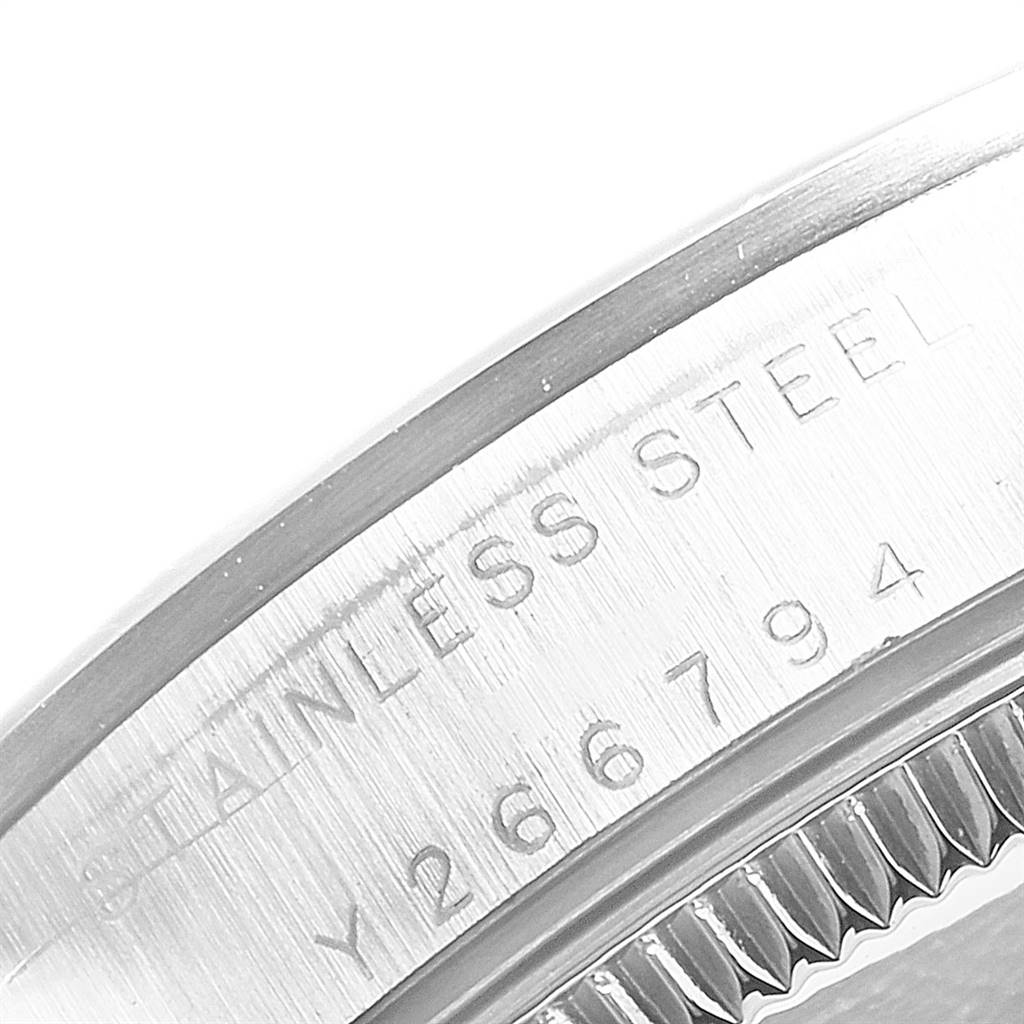 This image shows a close-up angle of the back casing, specifically highlighting serial engraving, of a mid-size Rolex watch.