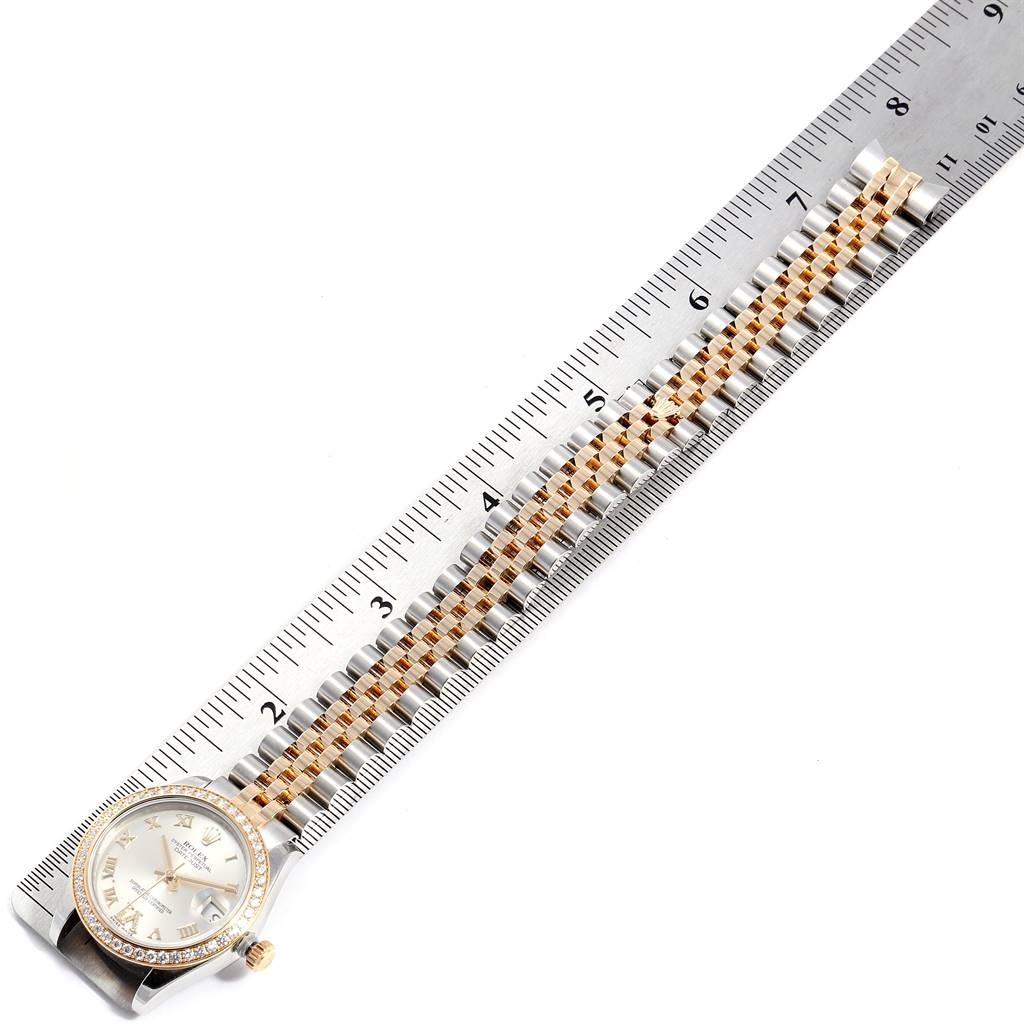 The Rolex Mid-Size 178383 Women's Steel and Gold (two tone) Silver Dial 178383 Women's Steel and Gold (two tone) Silver Dial watch is shown from a top-down angle, displaying the face and entire length of the bracelet alongside a ruler.