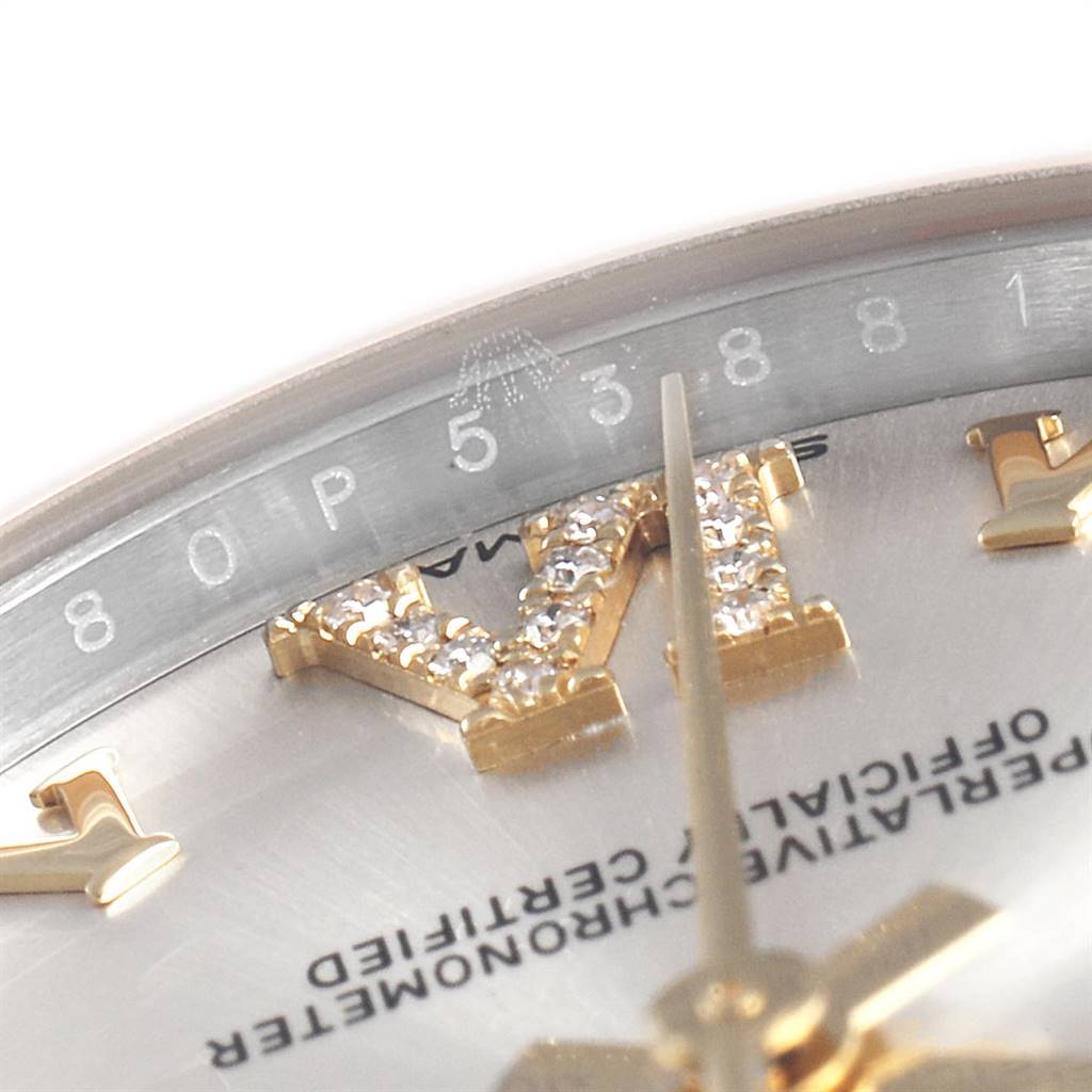 This close-up image of a Rolex Mid-Size 178273 Women's Steel and Gold (two tone) Silver Dial 178273 Women's Steel and Gold (two tone) Silver Dial model watch focuses on the dial, showing part of the markers, text, and the serial number.
