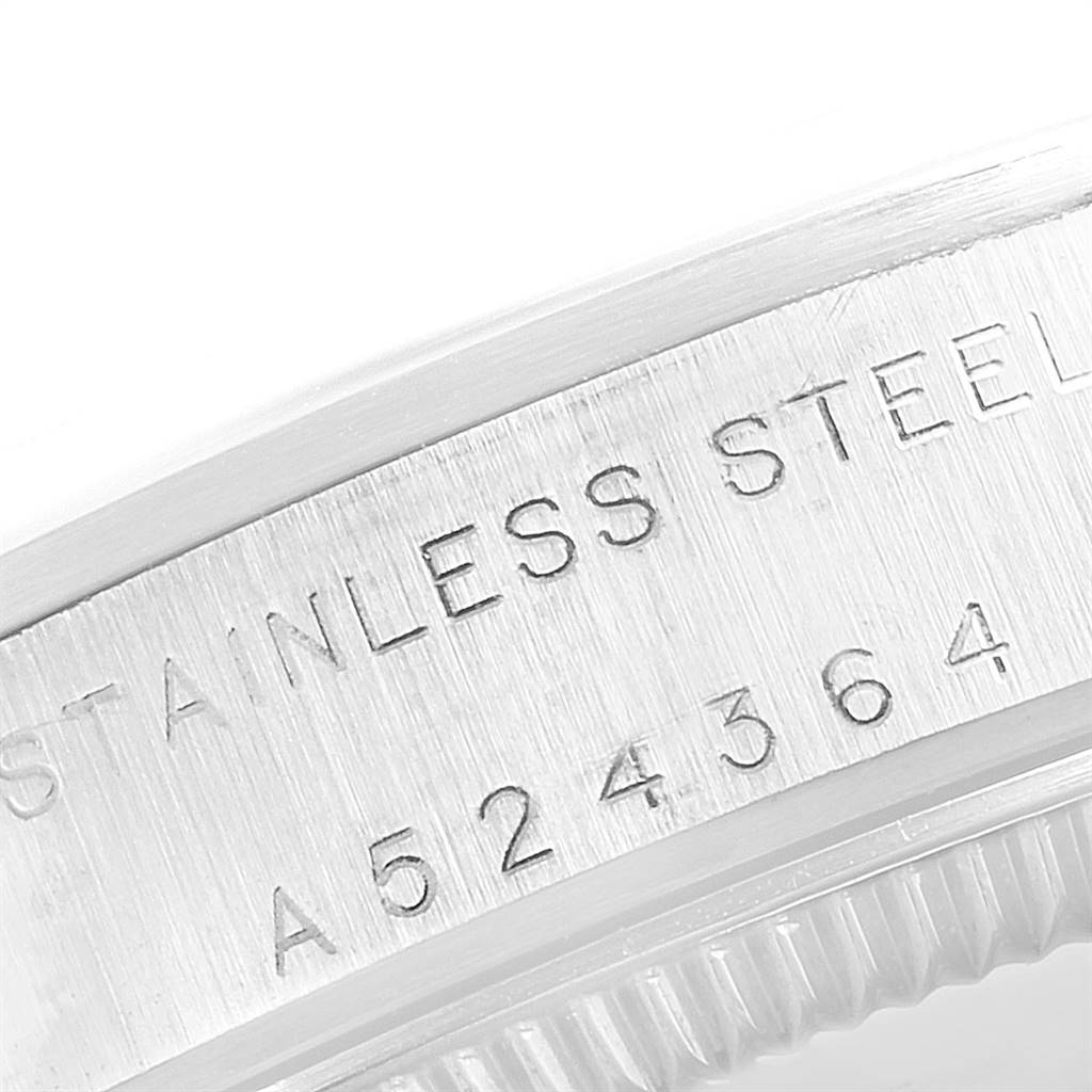 The image shows a close-up of the side of the bezel with "STAINLESS STEEL" and a serial number engraved on a Mid-Size Rolex watch.