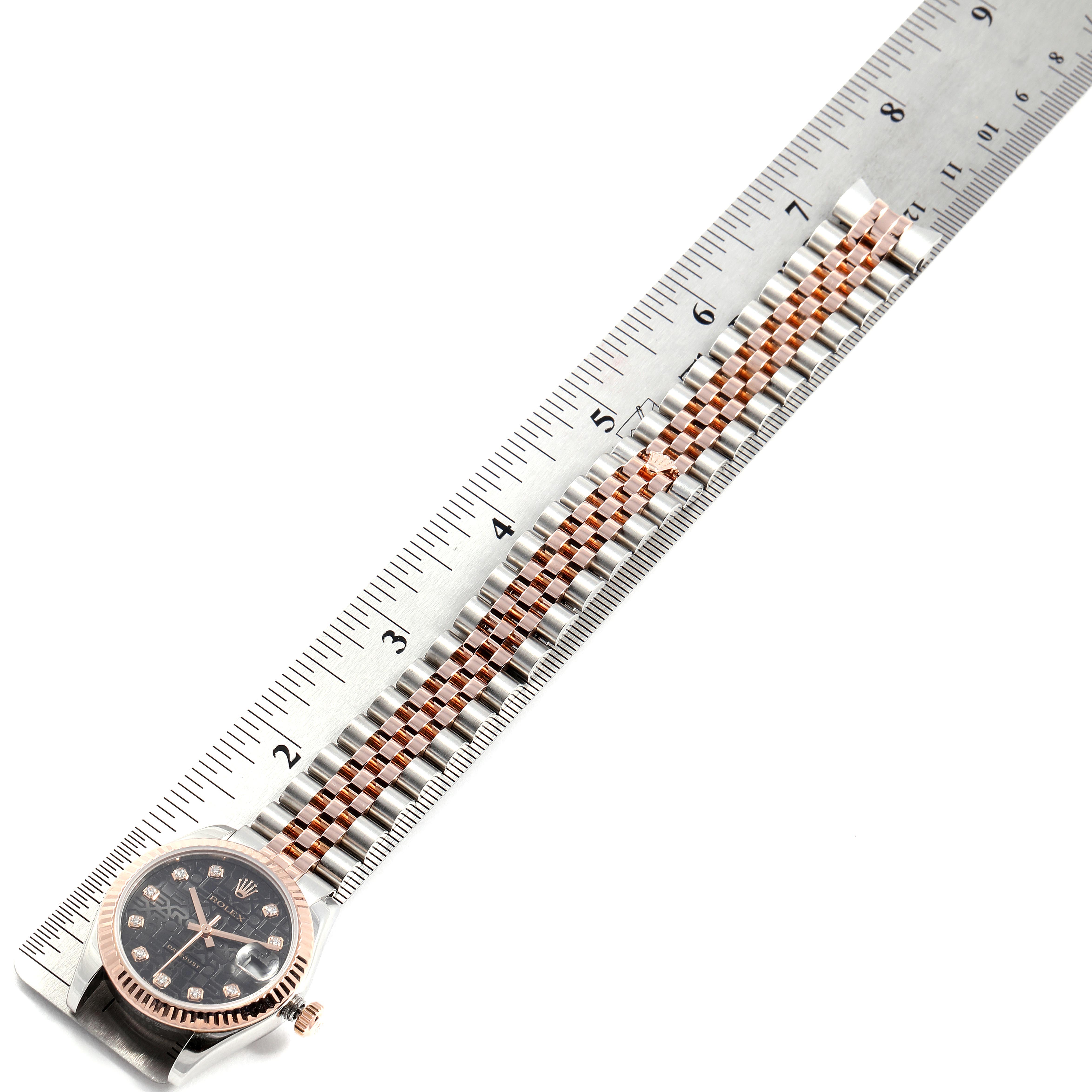 The image shows a Rolex Mid-Size 178271 Women's Steel and Gold (two tone) Black Dial 178271 Women's Steel and Gold (two tone) Black Dial watch with its band and face placed along a measuring ruler.