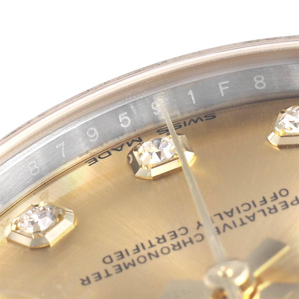 This close-up image of a Rolex Mid-Size 178273 Women's Steel and Gold (two tone) Champagne Dial 178273 Women's Steel and Gold (two tone) Champagne Dial watch shows the dial with diamond hour markers and the edge of the watch face from an oblique angle.