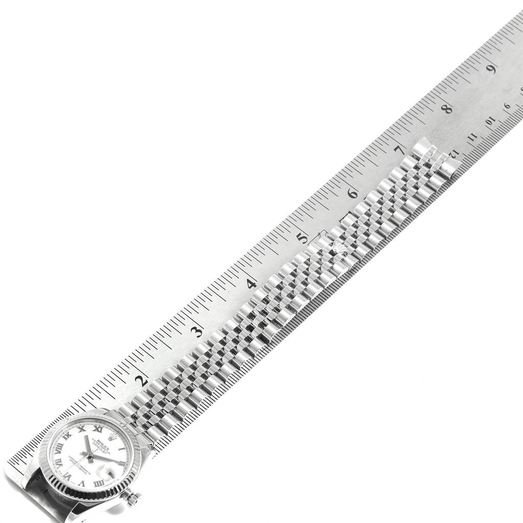 The Rolex Mid-Size 178274 Women's Stainless Steel White Dial 178274 Women's Stainless Steel White Dial watch is shown from a top-down angle, featuring the face and band next to a ruler for scale.