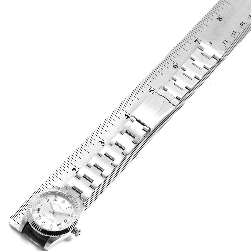 The Rolex Mid-Size 177234 Women's Stainless Steel Silver Dial 177234 Women's Stainless Steel Silver Dial model watch is shown from an overhead angle, highlighting the face, bracelet, and clasp, with a ruler beside it for scale.