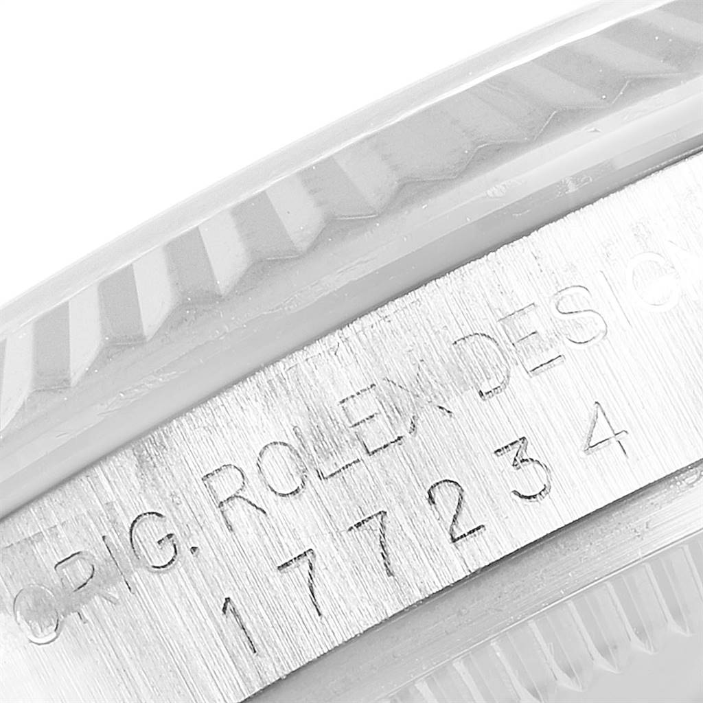 This close-up image shows the engraved serial number and part of the bezel of a Mid-Size Rolex watch.