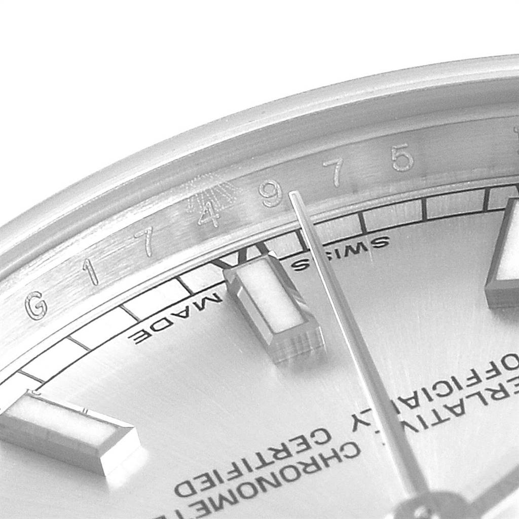 This image shows a close-up of the dial and bezel of a Mid-Size Rolex watch, highlighting the hands, markers, and some text.