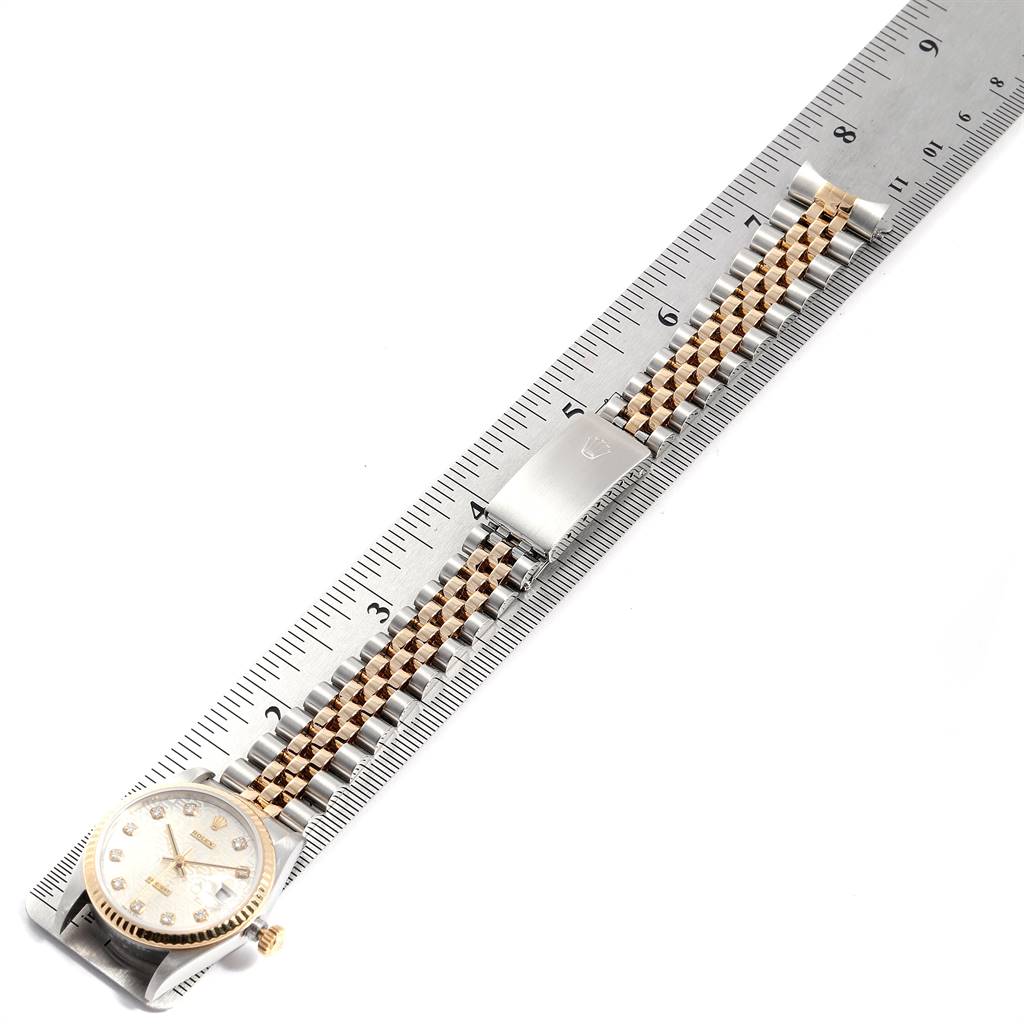 The image shows a Mid-Size Rolex watch placed alongside a ruler, displaying the watch face, bracelet, and clasp.