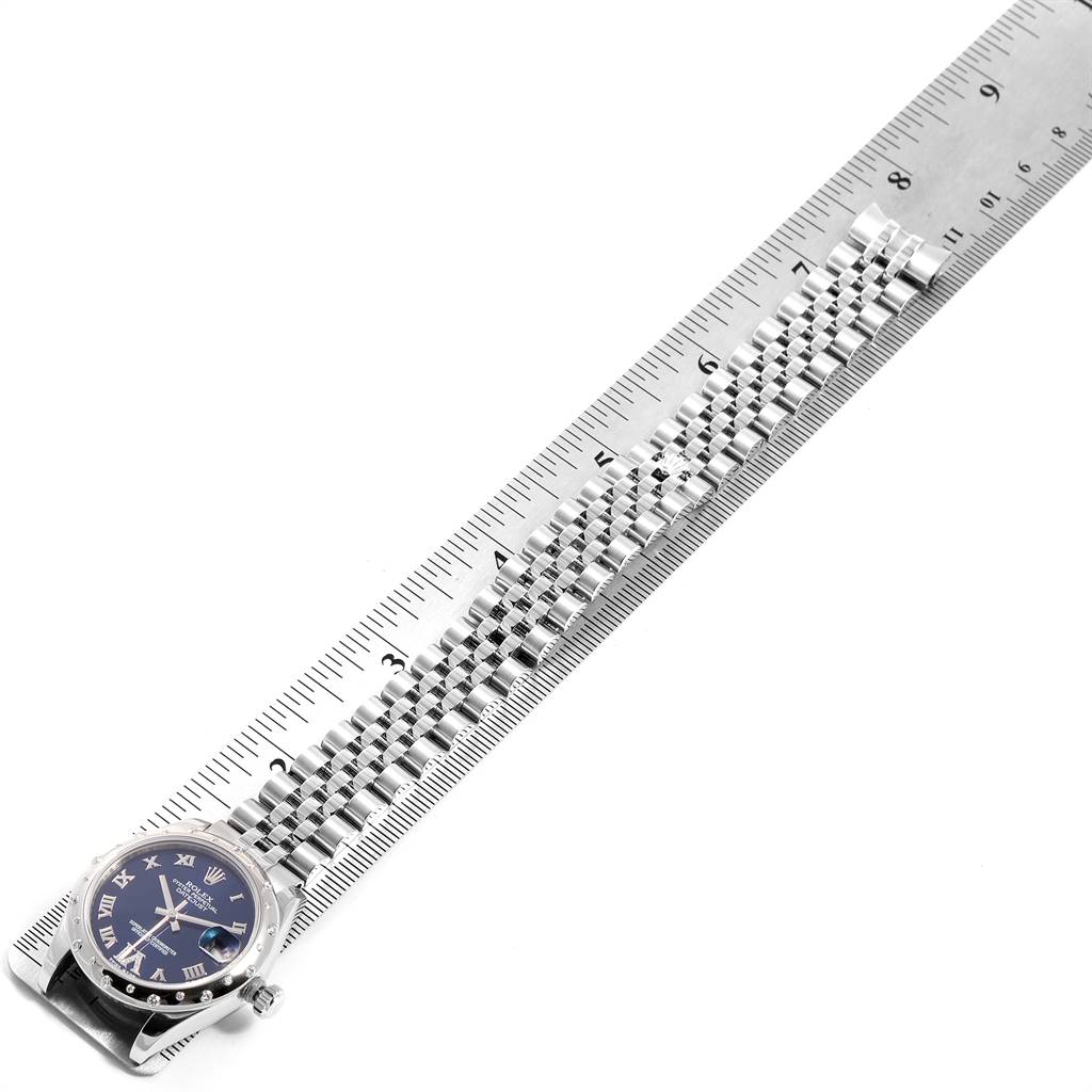 This image shows the Rolex Mid-Size 178344 Women's Stainless Steel Blue Dial 178344 Women's Stainless Steel Blue Dial watch laid flat with its band extended and measured against a ruler.