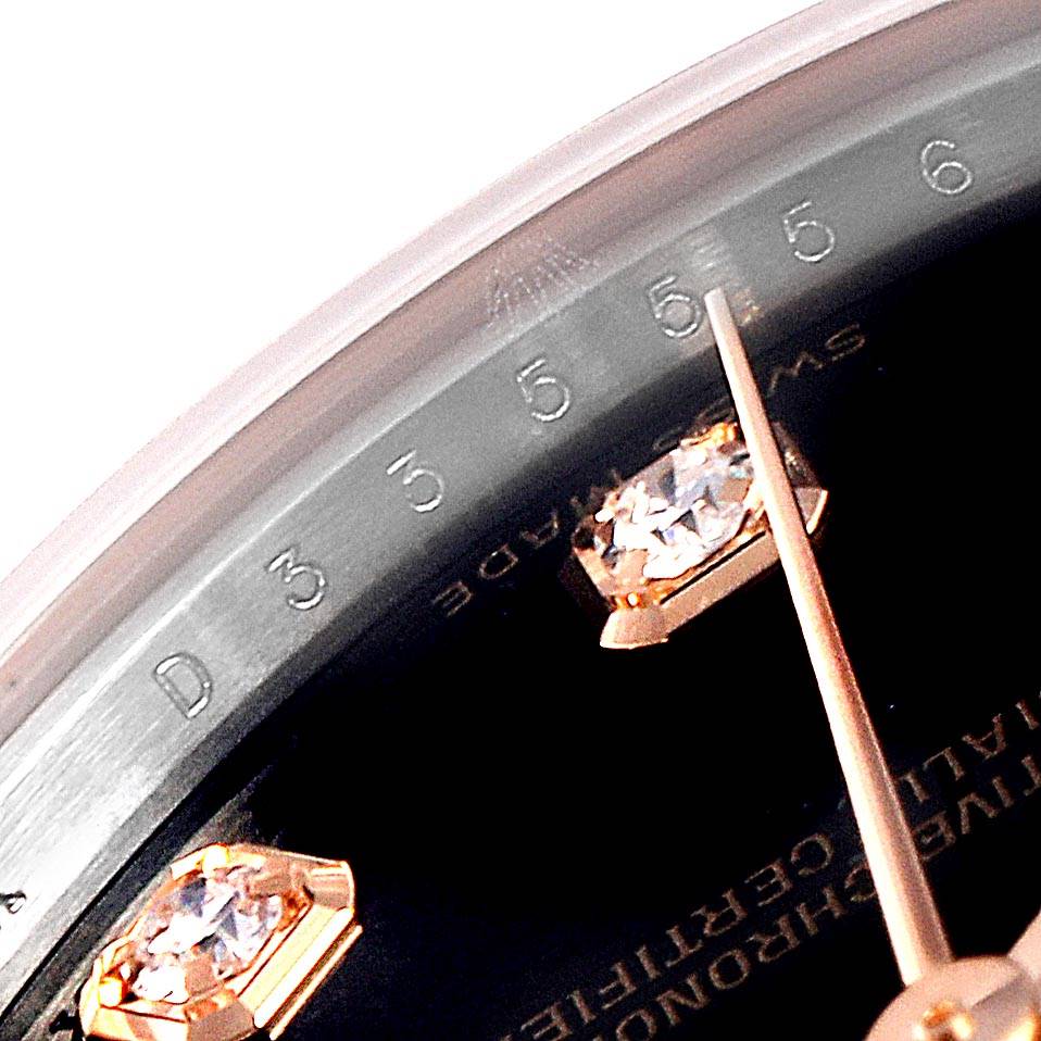 This close-up image of the Mid-Size Rolex watch shows part of the dial, including its diamond hour markers and the minute hand.