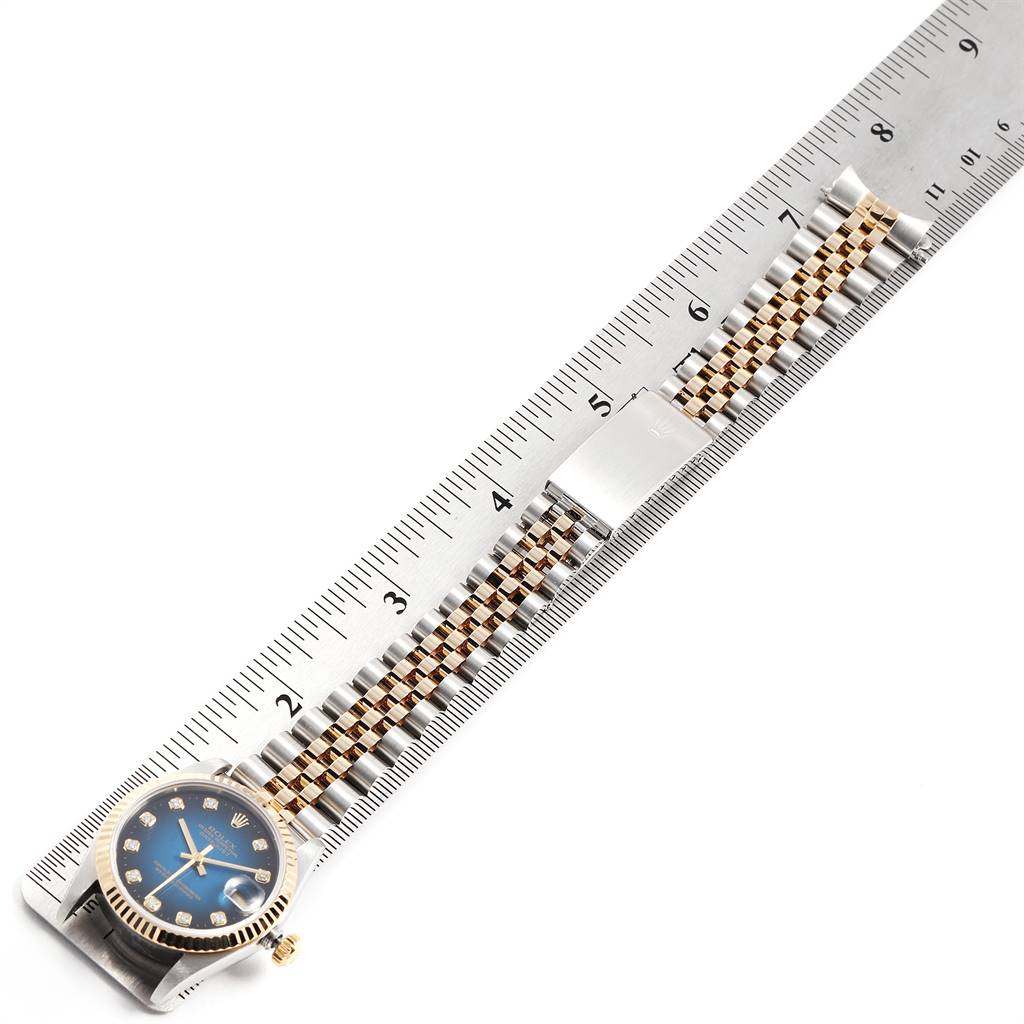 This image shows a Rolex Mid-Size 78273 Women's Steel and Gold (two tone) Blue Dial 78273 Women's Steel and Gold (two tone) Blue Dial model watch laid flat next to a ruler, displaying its face, bezel, and metal bracelet.