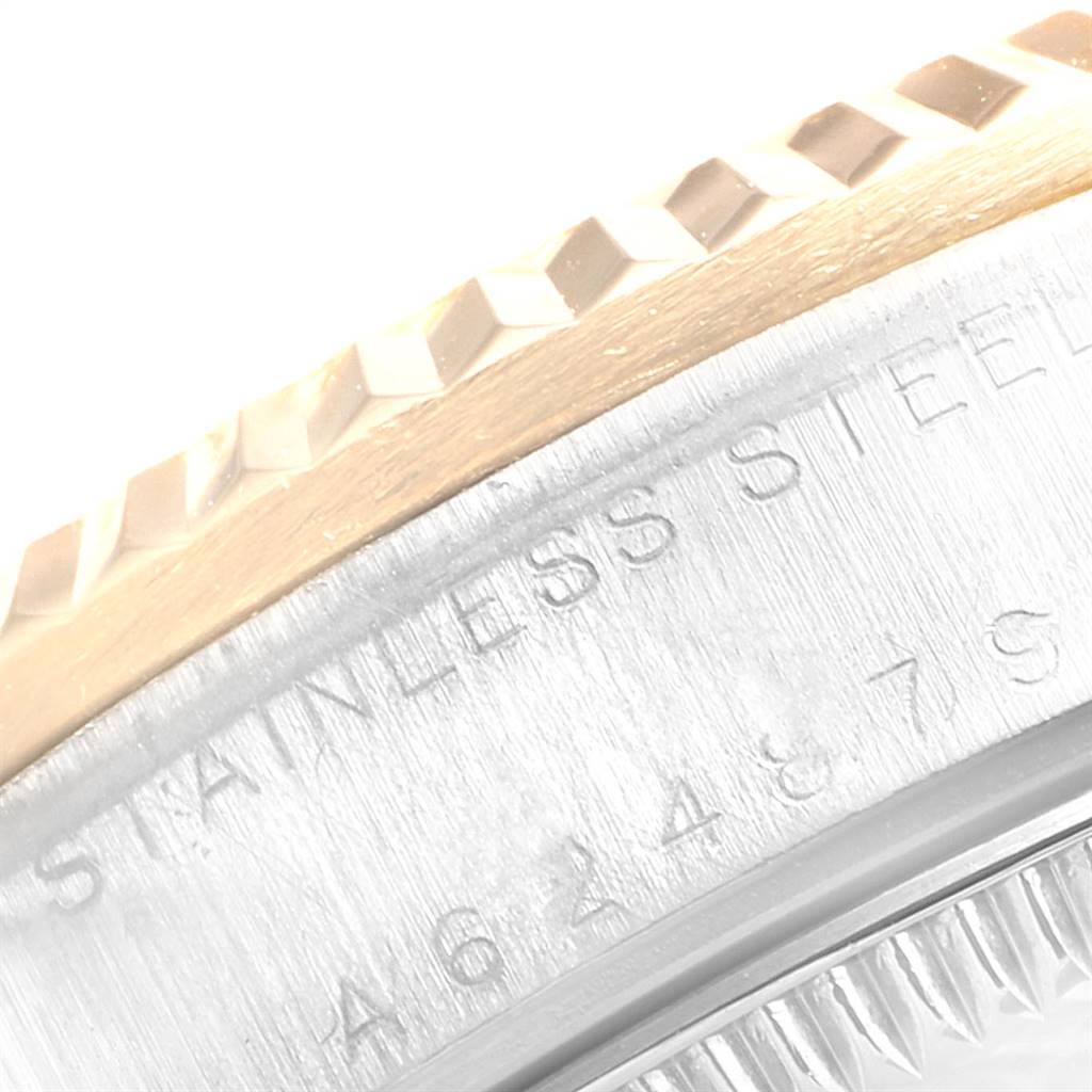 This close-up image of a Rolex Mid-Size 78273 Women's Steel and Gold (two tone) Blue Dial 78273 Women's Steel and Gold (two tone) Blue Dial model watch shows part of the bezel and engraved text on the stainless steel case.
