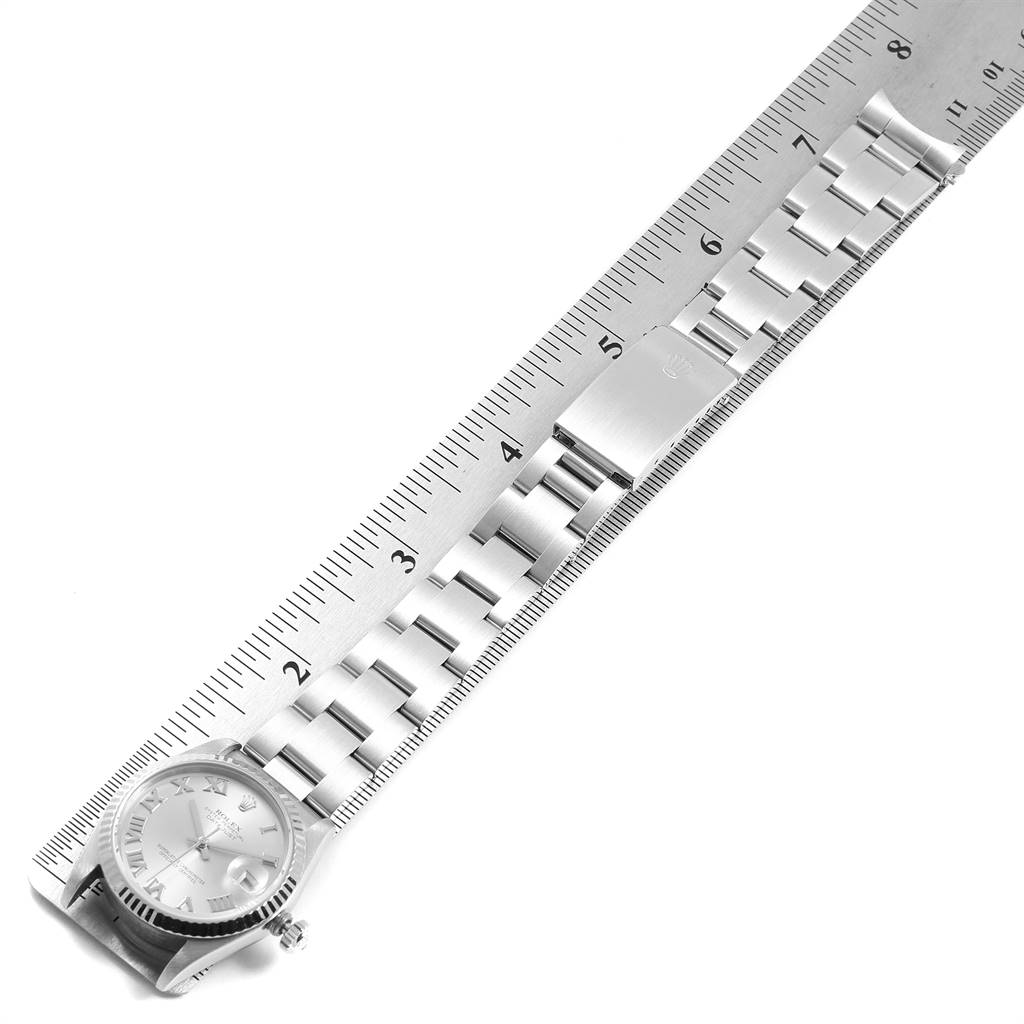 The image shows the Rolex Mid-Size 68274 Women's Stainless Steel Silver Dial 68274 Women's Stainless Steel Silver Dial watch laid flat, displaying its dial, bracelet, and clasp, alongside a ruler for scale.
