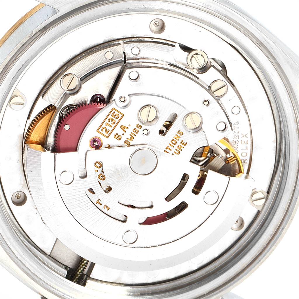 This image shows the internal mechanical movement of a Mid-Size Rolex watch, highlighting gears, springs, and the rotor.