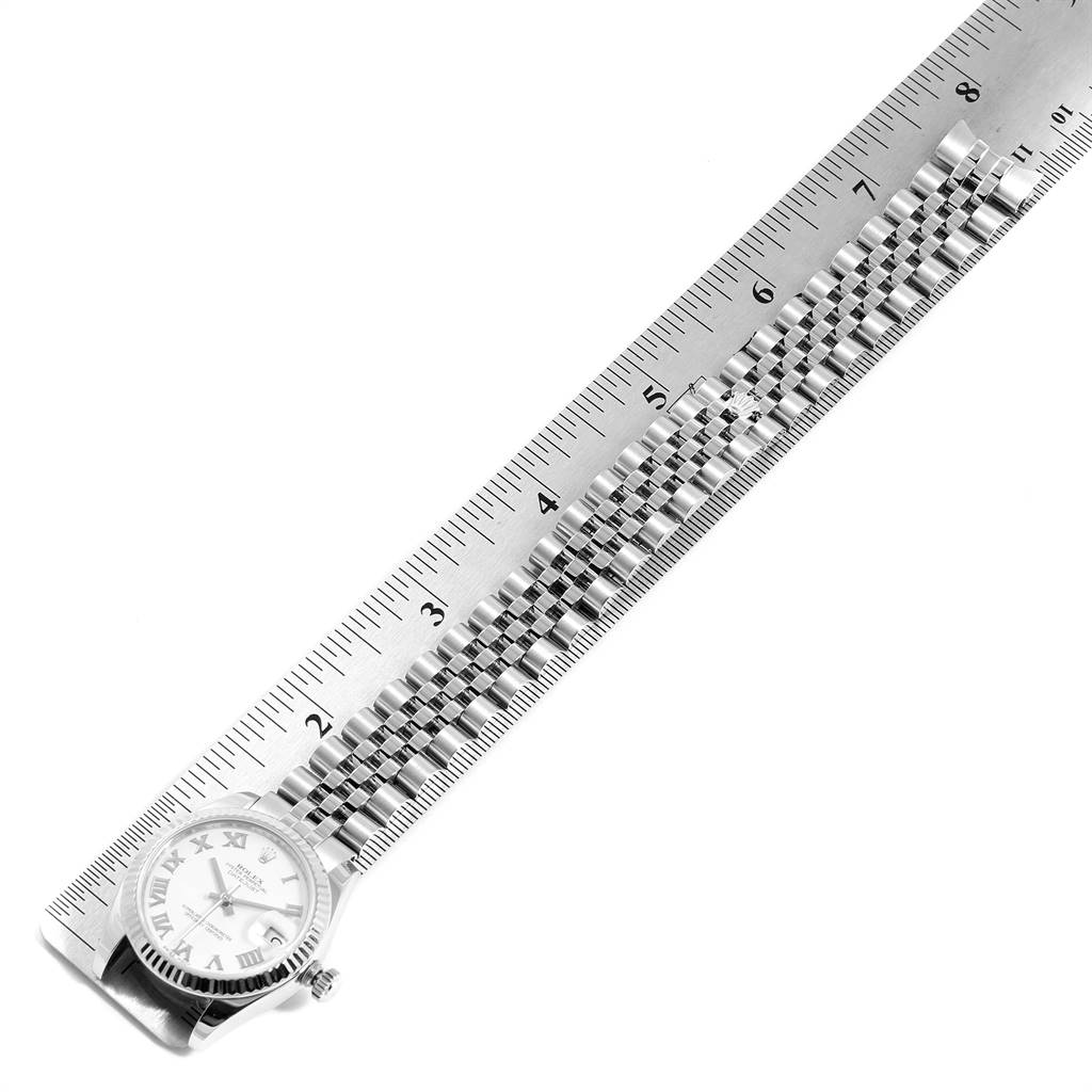 The Rolex Mid-Size 178274 Women's Stainless Steel White Dial 178274 Women's Stainless Steel White Dial watch is shown laying flat with the band extended and measured against a ruler.