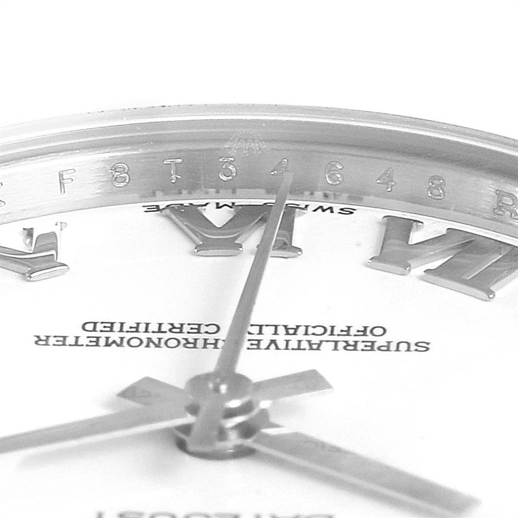The close-up image of the Mid-Size Rolex watch displays part of the dial, hour markers, hands, and inner bezel with serial markings.