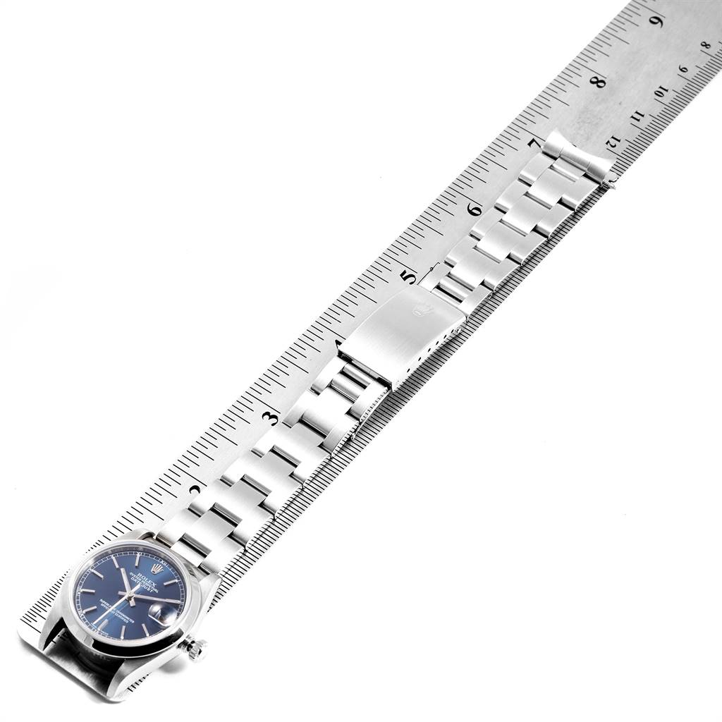 The Rolex Mid-Size 78240 Women's Stainless Steel Blue Dial 78240 Women's Stainless Steel Blue Dial model watch is shown from the front, displaying the face, bracelet, and clasp aligned next to a ruler.