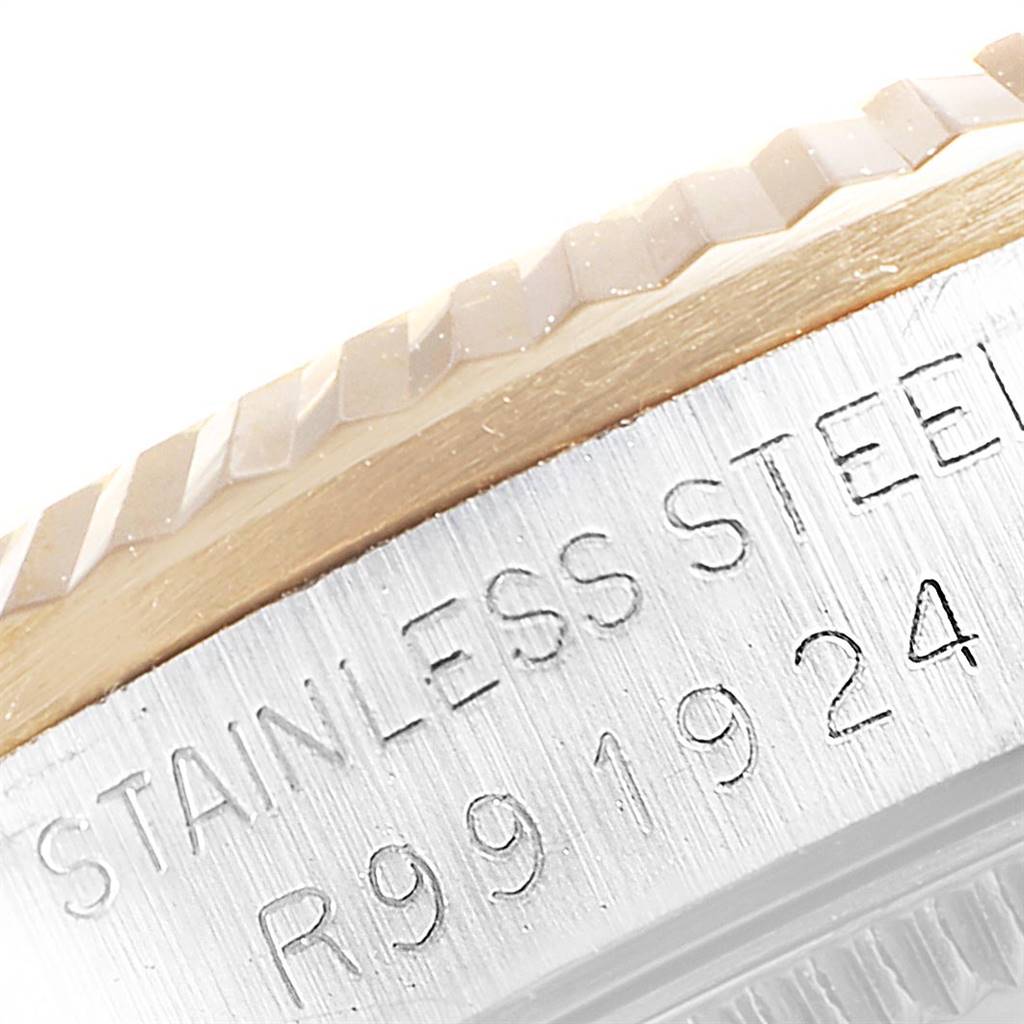 This image shows a close-up of the bezel and engraved stainless steel casing on a mid-size Rolex watch.