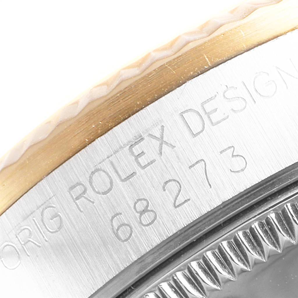 This close-up image shows the bezel and part of the case of a Rolex Mid-Size 68273 Women's Steel and Gold (two tone) White Dial 68273 Women's Steel and Gold (two tone) White Dial model, with the engraving "ORIG ROLEX DESIGN 68273".